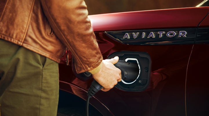 A hand is shown plugging in the charger into the charging port of a 2021 Lincoln Aviator | Bluebonnet Motors Lincoln in New Braunfels TX