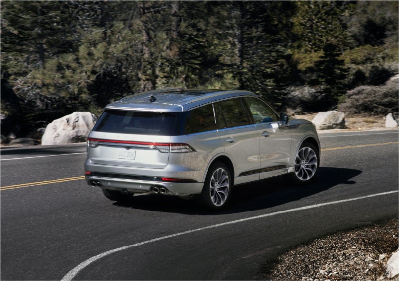 A 2023 Lincoln Aviator® Grand Touring model is shown being driven on a tight turn of a mountain road | Bluebonnet Motors Lincoln in New Braunfels TX