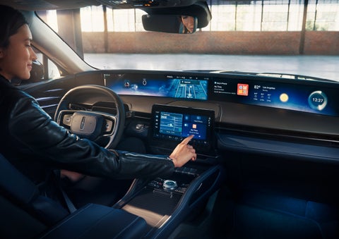 The driver of a 2024 Lincoln Nautilus® SUV interacts with the center touchscreen. | Bluebonnet Motors Lincoln in New Braunfels TX
