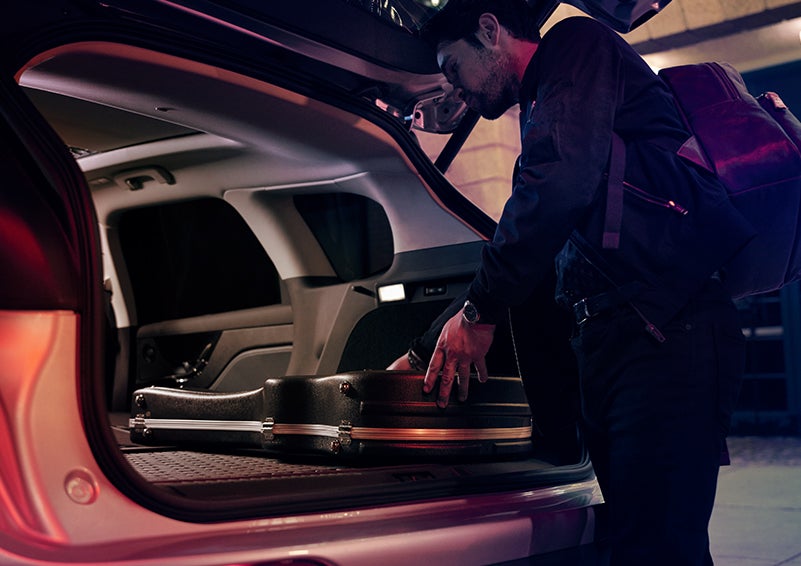 A man is shown loading cargo into the rear of a 2024 Lincoln Corsair® SUV with the second-row seats folded flat. | Bluebonnet Motors Lincoln in New Braunfels TX
