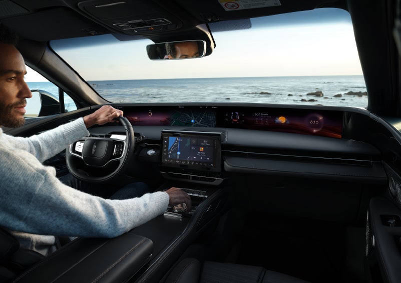 A driver of a parked 2024 Lincoln Nautilus® SUV takes a relaxing moment at a seaside overlook while inside his Nautilus. | Bluebonnet Motors Lincoln in New Braunfels TX