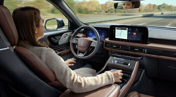 A woman is seen sitting in the driver’s seat of her 2025 Lincoln Aviator® SUV with her hands off the steering wheel. | Bluebonnet Motors Lincoln in New Braunfels TX