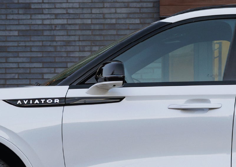 The driver’s side door and fender badging of a white 2026 Lincoln Aviator® SUV are showcased. | Bluebonnet Motors Lincoln in New Braunfels TX