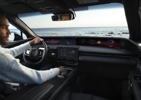 A driver of a parked 2026 Lincoln Nautilus® SUV takes a relaxing moment at a seaside overlook while inside his Nautilus. | Bluebonnet Motors Lincoln in New Braunfels TX