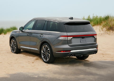A 2027 Lincoln Aviator® SUV is parked next to sand dunes. | Bluebonnet Motors Lincoln in New Braunfels TX