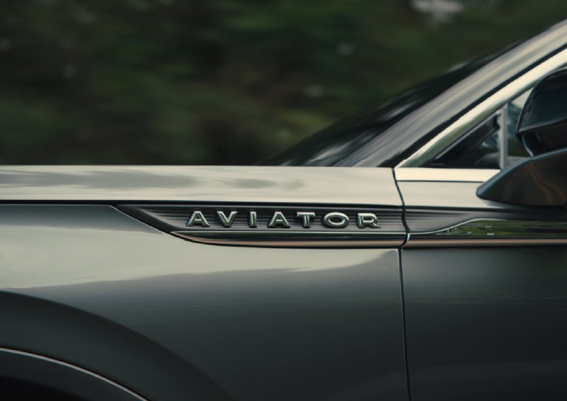 The driver’s side door and fender badging of a gray 2027 Lincoln Aviator® SUV are showcased. | Bluebonnet Motors Lincoln in New Braunfels TX