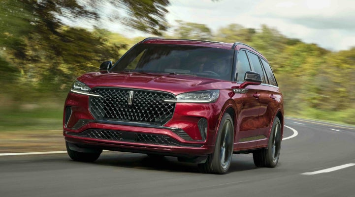A 2027 Lincoln Aviator® SUV is being driven on a country road | Bluebonnet Motors Lincoln in New Braunfels TX